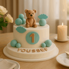 gâteau anniversaire 1 an personnalisé – Cake design rond avec ourson en pâte à sucre, décor nuages et boules, disponible en chocolat au lait équilibré, rocher noisette, tout noisette ou tout pistache.