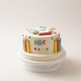 Cake design thème école sur mesure blanc orné de crayons de couleur sculptés, livres et lettres ABC - Deluxe Pâtisserie Tunis