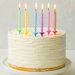 Bougies multicolores allumées sur un gâteau d’anniversaire
